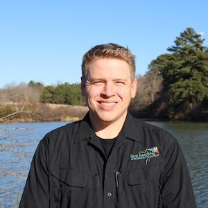 Smiling man by lake wearing black shirt