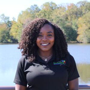 Smiling woman with curly hair by lake